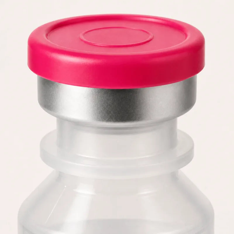 Macro close-up of the vial's pink flip-off cap and aluminum crimp seal